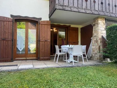 a table and chairs on the patio of a house at Appartement T2 avec jardinet proche du centre, Wi-Fi, garage - FR-1-624-61 in Samoëns