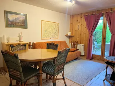a living room with a table and a bed at Appartement T2 avec jardinet proche du centre, Wi-Fi, garage - FR-1-624-61 in Samoëns