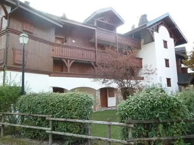 a large white building with a wooden balcony at Appartement T2 avec jardinet proche du centre, Wi-Fi, garage - FR-1-624-61 in Samoëns