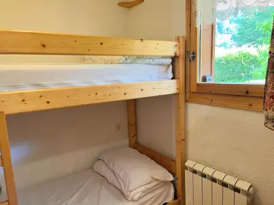 two bunk beds in a room with a window at Appartement T2 avec jardinet proche du centre, Wi-Fi, garage - FR-1-624-61 in Samoëns