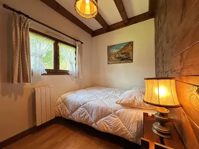 a bedroom with a bed and a lamp on a table at Chalet familial avec jardin et cheminée, animaux acceptés - FR-1-624-67 in Samoëns