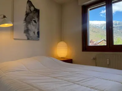 a bedroom with a bed with a wolf picture on the wall at Duplex familial cœur de village, animaux admis - FR-1-624-1 in Samoëns