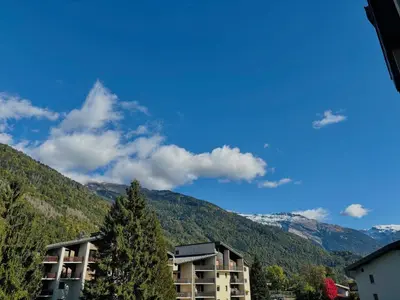 a building with a tree in front of a mountain at Studio lumineux au centre de Samoëns, vue sur Le Criou - FR-1-624-52 in Samoëns