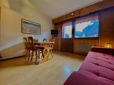 a living room with a table and chairs and a couch at Studio lumineux au centre de Samoëns, vue sur Le Criou - FR-1-624-52 in Samoëns