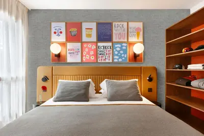 a bedroom with a bed and a wall with posters at RockyPop Flaine Hotel & Spa in Flaine