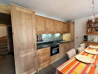 a kitchen with wooden cabinets and a table with a table sidx sidx at Superbe duplex, proche télécabine, animaux acceptés - FR-1-624-13 in Samoëns