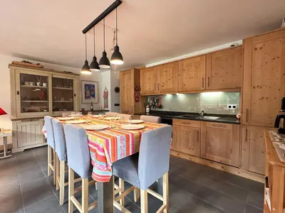 a kitchen with a table with chairs and cabinets at Superbe duplex, proche télécabine, animaux acceptés - FR-1-624-13 in Samoëns