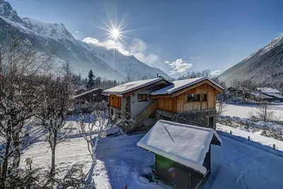 a cabin in the snow with mountains in the background at Chalet Breitalps in Chamonix-Mont-Blanc