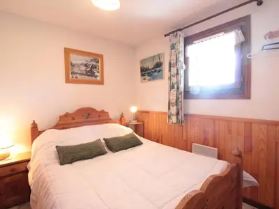 a bedroom with a large white bed with a window at 2P au centre avec parking proche des pistes pour 4 pers - FR-1-572-65 in Les Carroz d'Araches