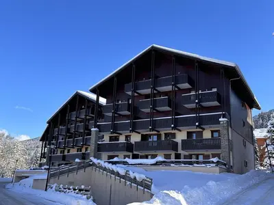 a large building with snow in front of it at 2P au centre avec parking proche des pistes pour 4 pers - FR-1-572-65 in Les Carroz d'Araches