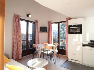 a kitchen and a living room with a table and chairs at Duplex 2P/4 avec Balcon, WIFI et Parking Les Carroz - FR-1-572-15 in Les Carroz d'Araches