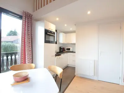 a kitchen with a table and chairs and a window at Duplex 2P/4 avec Balcon, WIFI et Parking Les Carroz - FR-1-572-15 in Les Carroz d'Araches
