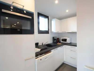 a kitchen with white cabinets and a stove top oven at Duplex 2P/4 avec Balcon, WIFI et Parking Les Carroz - FR-1-572-15 in Les Carroz d'Araches