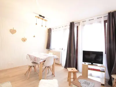 a living room with a table and chairs and a television at Charme au centre d'Arâches : 2 pièces + coin montagne, 4/5 pers, proche pistes et commerces - FR-1-572-154 in Les Carroz d'Araches