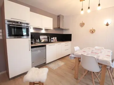 a kitchen with a table and a kitchen with white cabinets at Charme au centre d'Arâches : 2 pièces + coin montagne, 4/5 pers, proche pistes et commerces - FR-1-572-154 in Les Carroz d'Araches