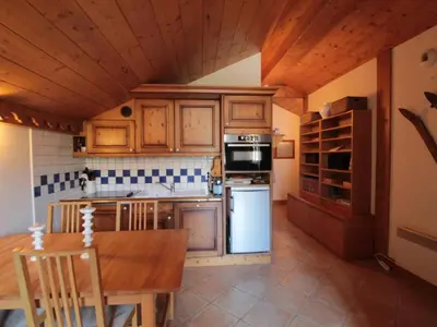 a kitchen with wooden cabinets and a wooden table and a table and a tableablish at 4 pièces spacieux bien équipé avec Wi-Fi et parking, au pied du ski bus - FR-1-572-241 in Les Carroz d'Araches