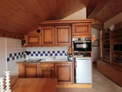 a kitchen with wooden cabinets and a white refrigerator at 4 pièces spacieux bien équipé avec Wi-Fi et parking, au pied du ski bus - FR-1-572-241 in Les Carroz d'Araches