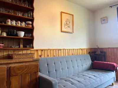 a living room with a blue couch in a room at Appartement skis aux pieds, balcon, parking privé - FR-1-624-15 in Samoëns