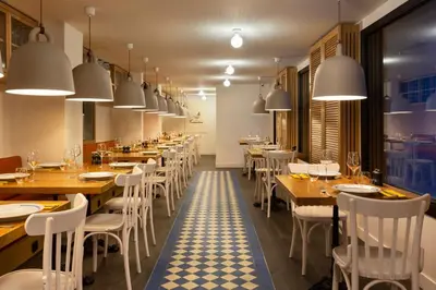 a restaurant with wooden tables and white chairs at RockyPop Flaine Appartements & Spa in Flaine