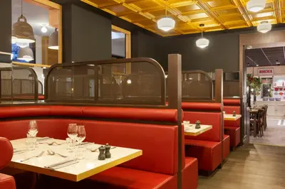 a restaurant with two tables and red booths at RockyPop Flaine Appartements & Spa in Flaine