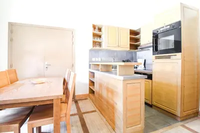 a kitchen with a wooden table and a dining room at Cosy, modern 2-bed with fireplace & beautiful views in Flaine