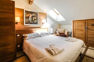 a bedroom with a bed with two towels on it at Cosy, modern 2-bed with fireplace & beautiful views in Flaine