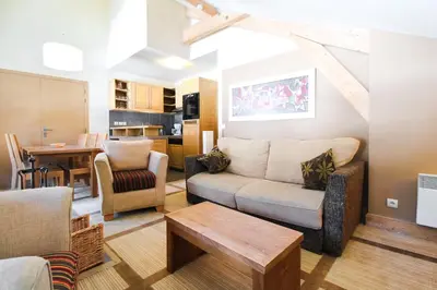 a living room with a couch and a table at Cosy, modern 2-bed with fireplace & beautiful views in Flaine