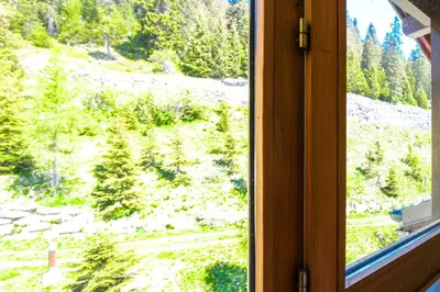 a window with a view of a mountain at Charming 6th-floor 2-bedroom apartment with fireplace in Flaine