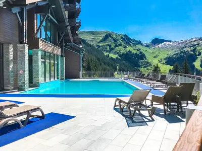 a swimming pool with mountains in the background at Charming 6th-floor 2-bedroom apartment with fireplace in Flaine