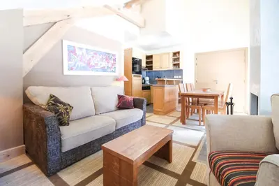 a living room with a couch and a table at Charming 6th-floor 2-bedroom apartment with fireplace in Flaine