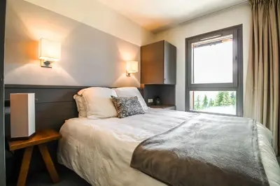 a bedroom with a large bed and a window at South-facing renovated 2-bed apartment Les Terrasses d'Eos in Flaine