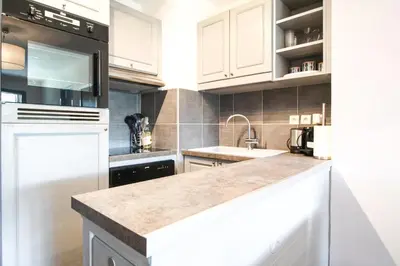 a kitchen with white cabinets and a counter top at South-facing renovated 2-bed apartment Les Terrasses d'Eos in Flaine