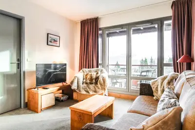 a living room with a couch and a tv at South-facing renovated 2-bed apartment Les Terrasses d'Eos in Flaine