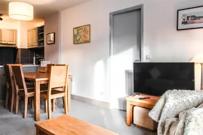a living room with a table and a dining room at South-facing renovated 2-bed apartment Les Terrasses d'Eos in Flaine