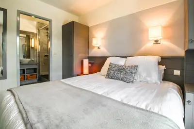 a bedroom with a large white bed with two pillows at South-facing renovated 2-bed apartment Les Terrasses d'Eos in Flaine