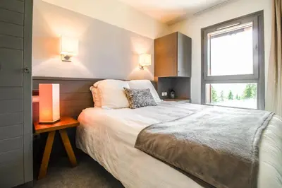 a bedroom with a large bed and a window at South-facing renovated 2-bed apartment Les Terrasses d'Eos in Flaine