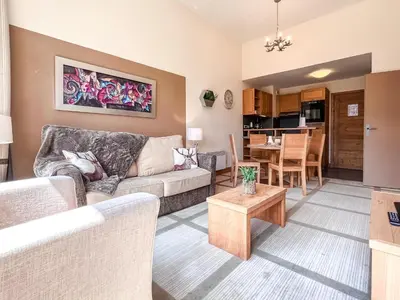 a living room with a couch and a table at Bright, spacious South-facing 1-bedroom apartment in Flaine