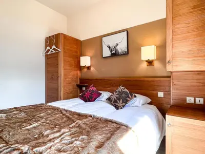 a bedroom with a large bed with two pillows on it at Bright, spacious South-facing 1-bedroom apartment in Flaine