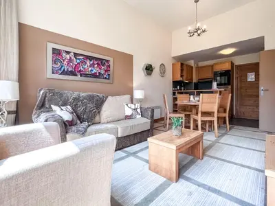 a living room with a couch and a table at Bright, spacious South-facing 1-bedroom apartment in Flaine