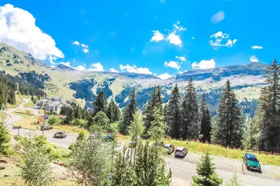 a road in the mountains with cars on it at Bright, spacious South-facing 1-bedroom apartment in Flaine