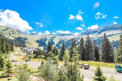 a road in the mountains with cars parked at Bright, spacious South-facing 1-bedroom apartment in Flaine