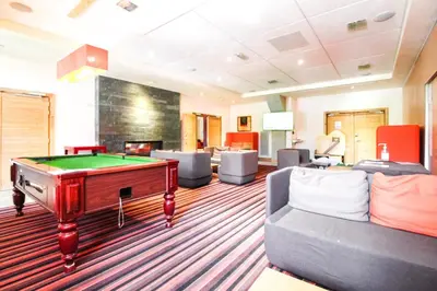 a billiard room with a pool table and couches at Large one-bedroom apartment, wheelchair adapted, Les Terrasses d'Eos in Flaine