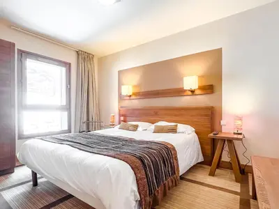 a hotel room with a large bed and a window at Large one-bedroom apartment, wheelchair adapted, Les Terrasses d'Eos in Flaine