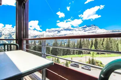 a room with a table and chairs and a large window at Stunning 3-bedroom apartment with mountain views in Flaine