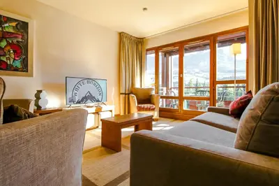 a kitchen with wooden cabinets and a sink at Stunning 3-bedroom apartment with mountain views in Flaine