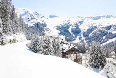 a house on a snowy mountain with snow covered trees at Stunning 3-bedroom apartment with mountain views in Flaine