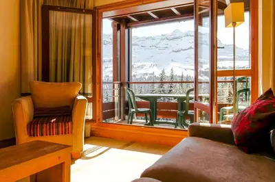 a living room with a window with a view of a mountain at Stunning 3-bedroom apartment with mountain views in Flaine