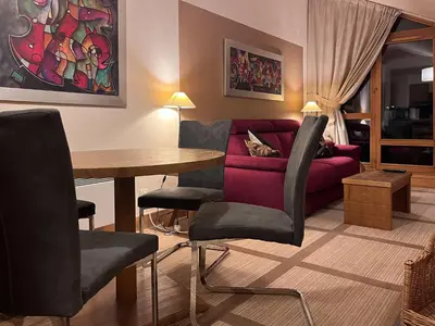 a living room with a red couch and a table at Beautiful one-bedroom apartment with fireplace and stunning views in Flaine