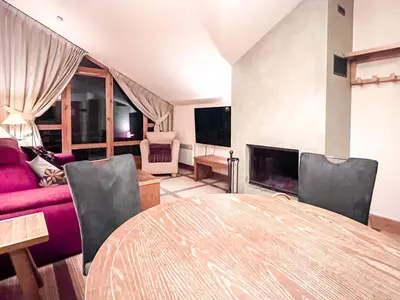 a living room with a table and a couch at Beautiful one-bedroom apartment with fireplace and stunning views in Flaine