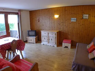 a living room with a table and a television at T2 calme à Samoëns - 4 pers, animaux admis - FR-1-629-70 in Samoëns